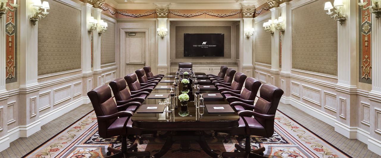 Interior of the Toscana Boardroom at Venetian set up for a meeting with a long boardroom table, chairs & table decor